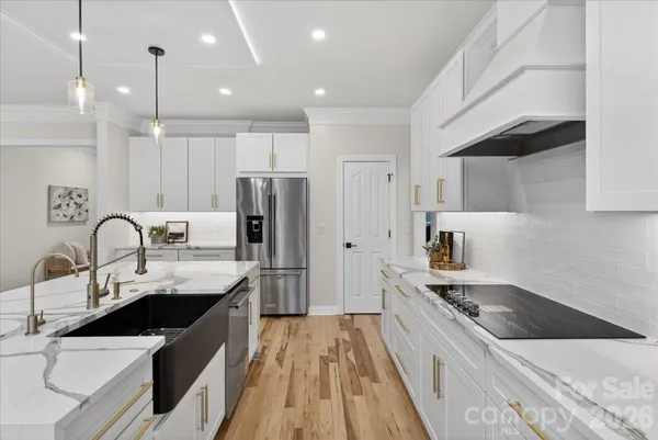 a kitchen with a sink a counter top space stainless steel appliances and cabinets