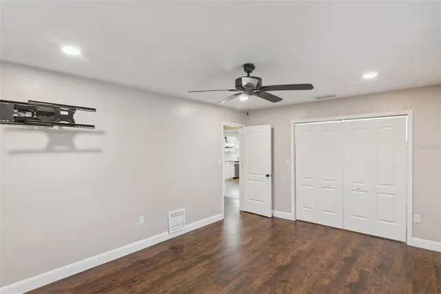 a view of a big room with wooden floor and windows