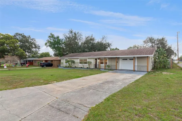 a front view of a house with a yard and trees