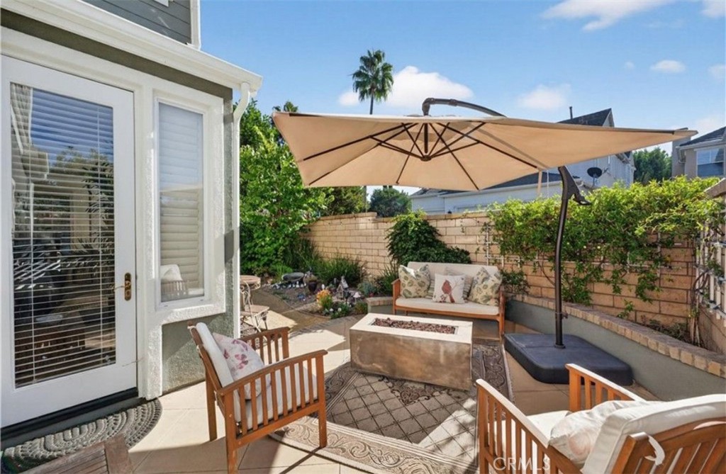 19 Sklar Street Ladera Ranch, CA 92694 - Photo 23 of 26 a view of a patio with couches table and chairs under an umbrella