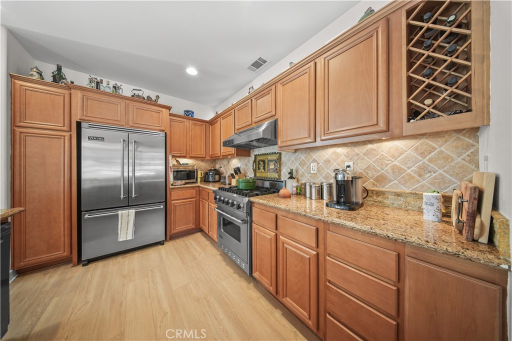 19 Sklar Street Ladera Ranch, CA 92694 - Photo 5 of 26 a kitchen with granite countertop a refrigerator oven a sink and dishwasher