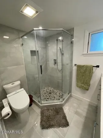 a bathroom with a toilet and a shower