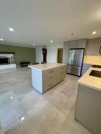 a large white kitchen with a large counter top and sink