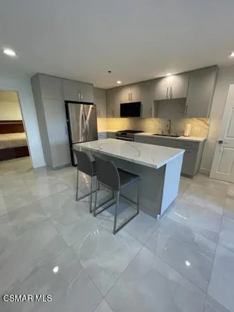 a living room with stainless steel appliances furniture a rug and a view