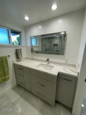 a bathroom with a double vanity sink and a mirror