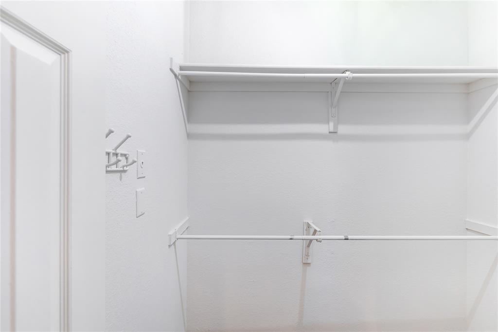 12680 Hillcrest Road, Unit 4101 Dallas, TX 75230 - Photo 31 of 37 White interior closet featuring a two-panel door, wall-mounted hooks, shelving, and hanging rods