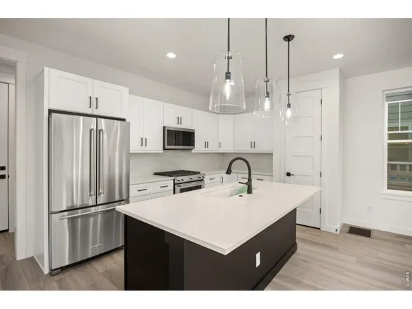 a kitchen with kitchen island a sink stainless steel appliances and cabinets