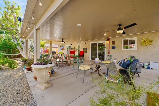 68110 Risueno Road Cathedral City, CA 92234 - Photo 16 of 33 a view of a patio with dining table and chairs and potted plants