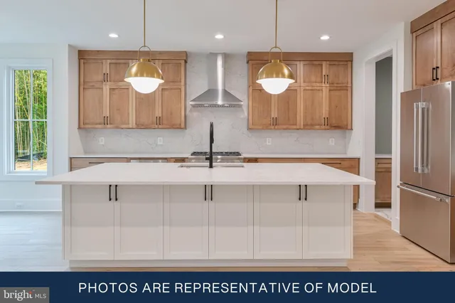 a kitchen with kitchen island white cabinets and refrigerator