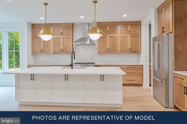 a large white kitchen with stainless steel appliances granite countertop a stove and a wooden floors