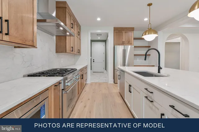a view of kitchen with stainless steel appliances granite countertop a sink and a refrigerator