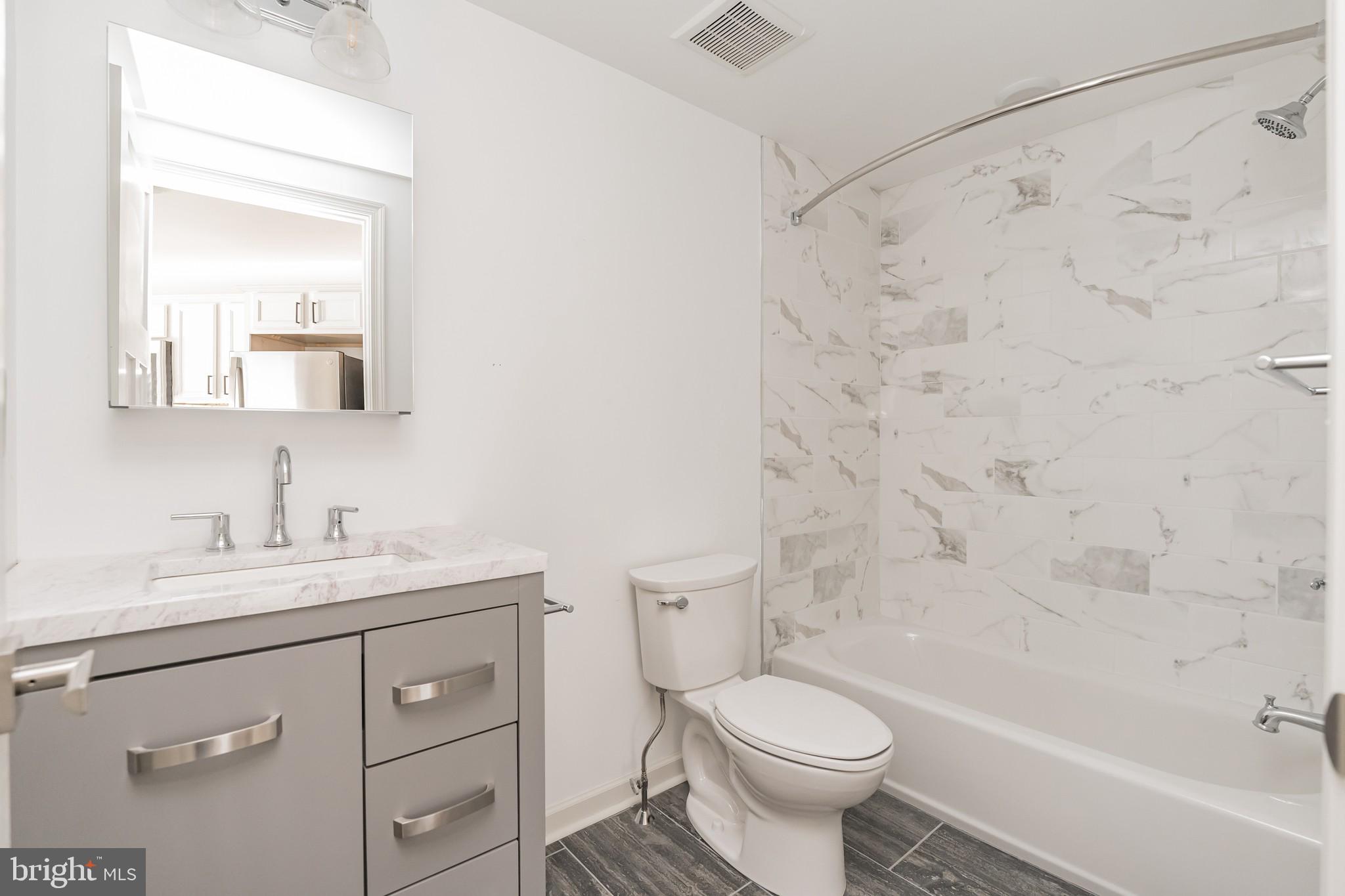 6649 Ridge Avenue, Unit A301 Philadelphia, PA 19128 - Photo 5 of 8 a bathroom with a sink a toilet and a bathtub