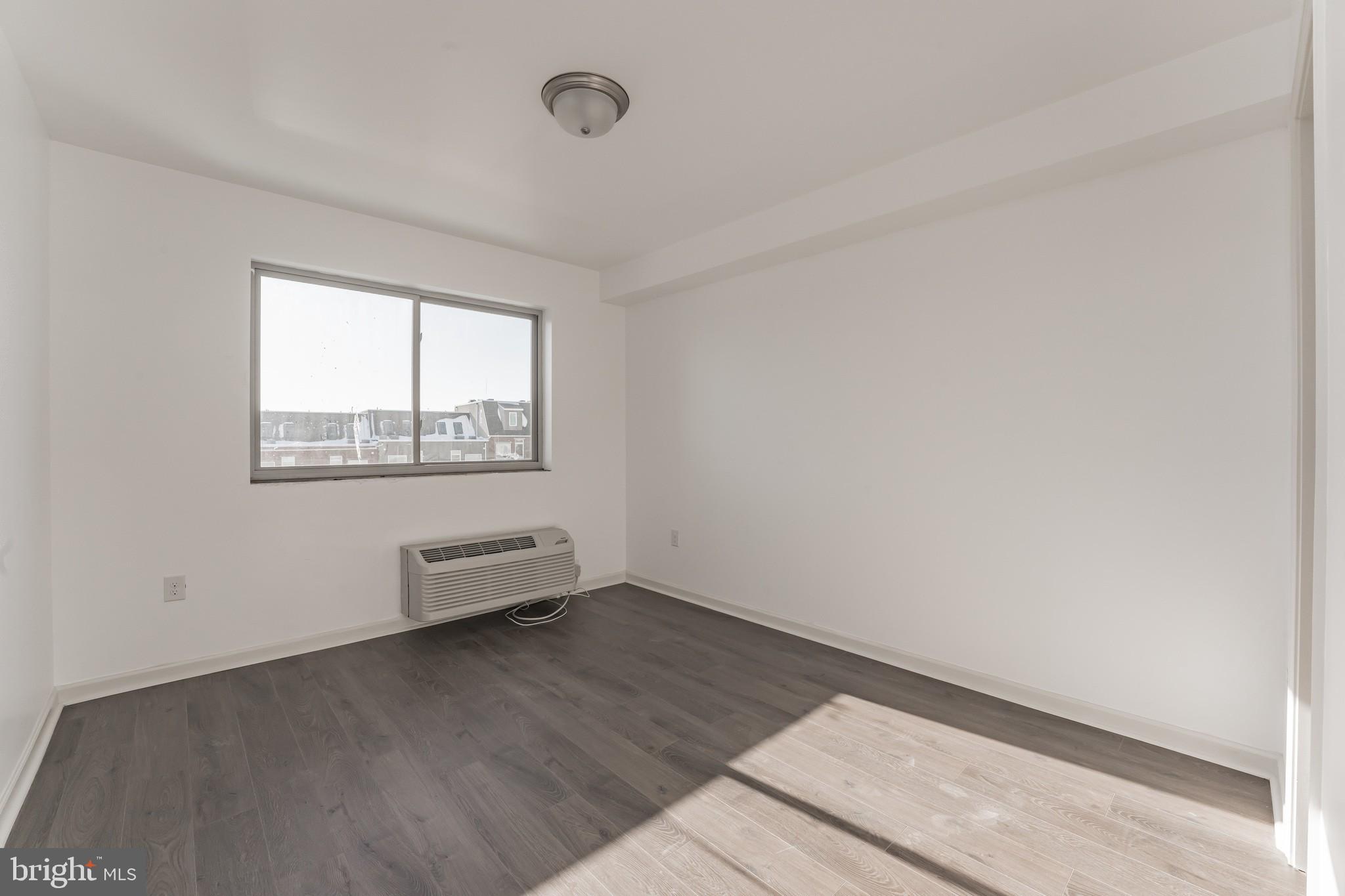 6649 Ridge Avenue, Unit A301 Philadelphia, PA 19128 - Photo 6 of 8 an empty room with wooden floor and windows