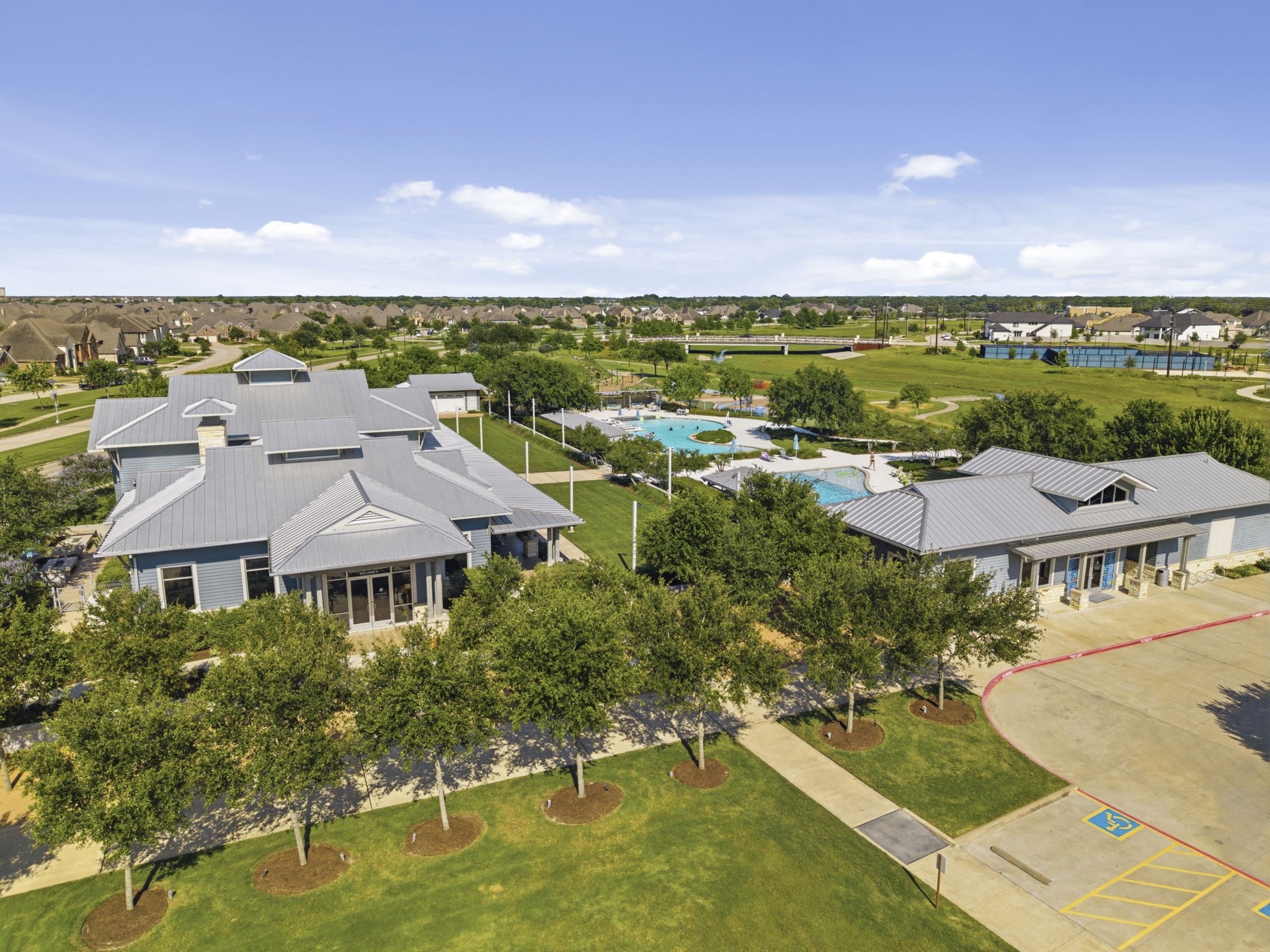 2119 Blackhawk Ridge Lane Manvel, TX 77578 - Photo 45 of 49 Pomona's stunning clubhouse and aquatic center — featuring resort-style pools, a splash pad, shaded lounging areas, open green lawns, scenic walking paths, and beautifully manicured grounds that set Pomona apart as a truly premier master-planned community.