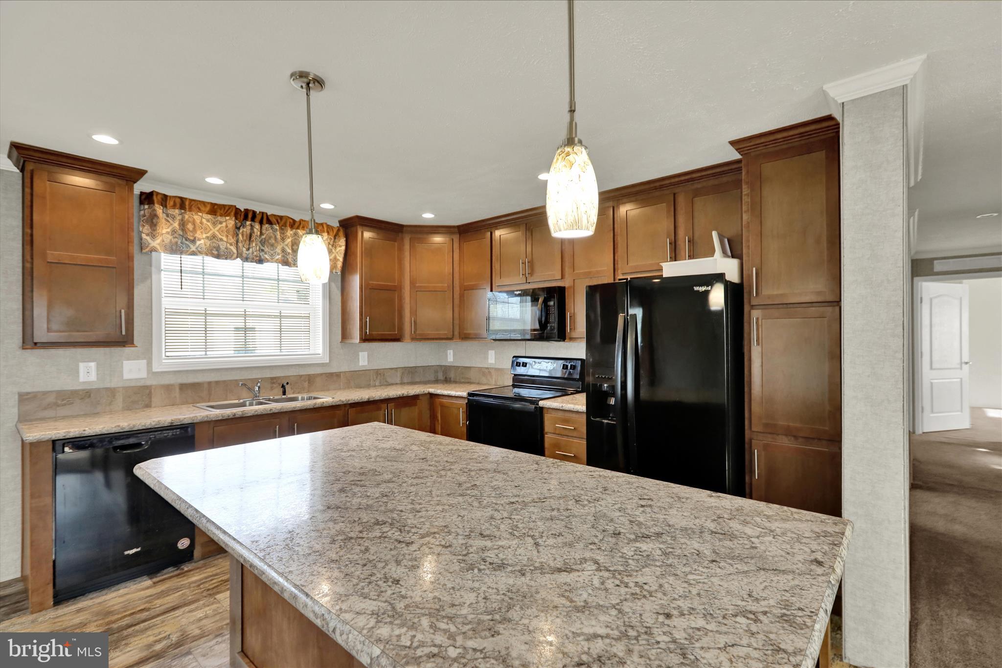 3450 Mountain Road, Unit M59 Hamburg, PA 19526 - Photo 12 of 35 a kitchen with stainless steel appliances granite countertop a refrigerator a sink a stove and a wooden floor