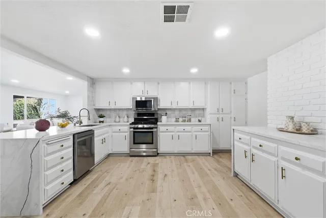 a kitchen with white cabinets appliances and sink