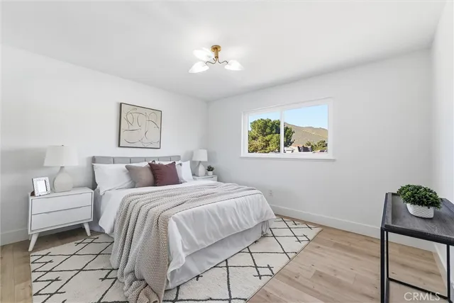 a bedroom with a large bed and a chandelier