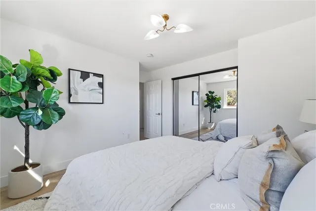 a bedroom with a bed and a potted plant