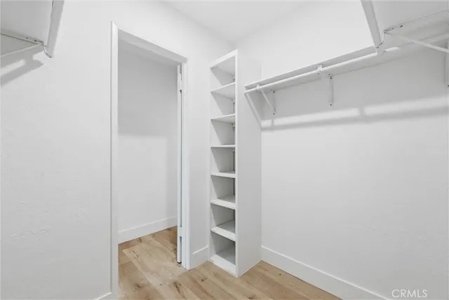 a view of walk in closet with empty racks