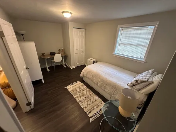 a bedroom with a bed and wooden floor