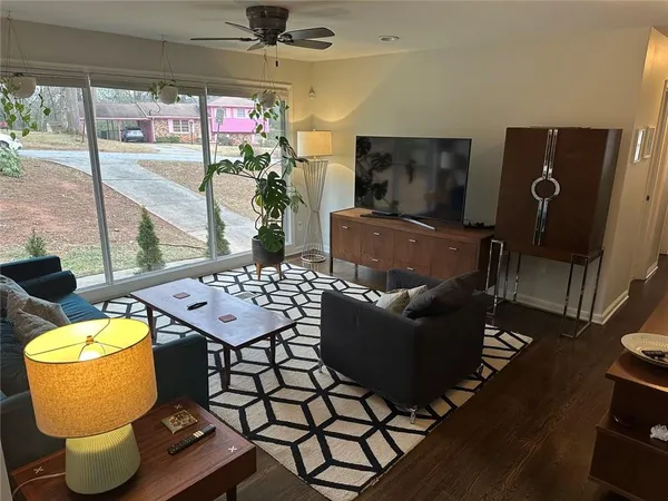a living room with furniture and a floor to ceiling window