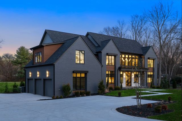a view of a big house with a big yard and large trees