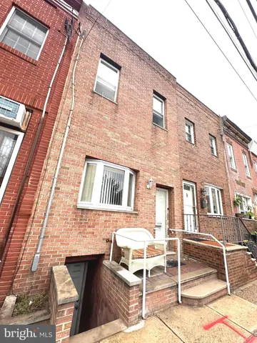 a view of an empty room with wooden floor and a ceiling fan
