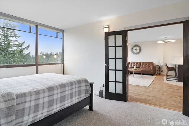 a bedroom with a bed and a large window