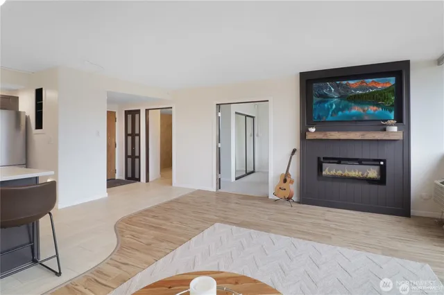 a view of a livingroom with wooden floor and a fireplace