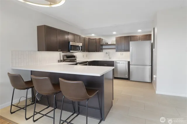a kitchen with kitchen island a sink stove and refrigerator