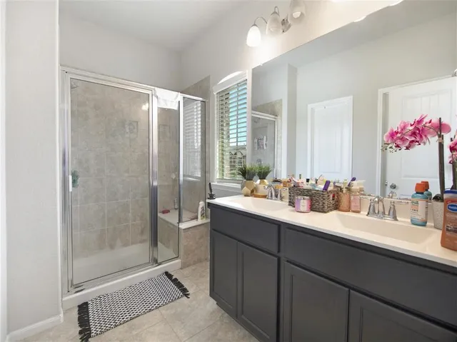 a bathroom with a double vanity sink mirror and shower