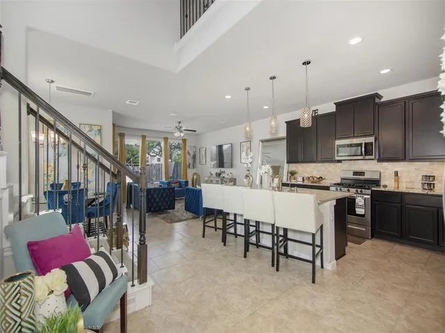 a kitchen with stainless steel appliances kitchen island granite countertop a refrigerator sink and cabinets