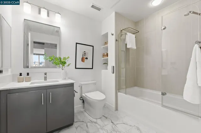 a bathroom with a double vanity sink toilet mirror and shower