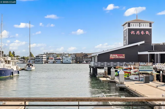 a view of a cafe with a couple of people seating under an umbrella