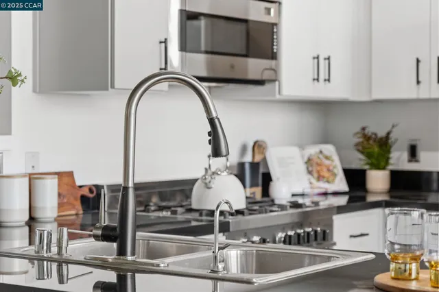 a kitchen with kitchen island granite countertop a stove and a sink with granite countertops