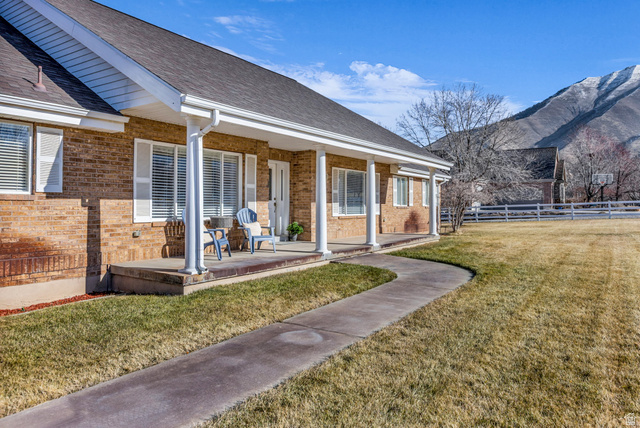 1060 West 2620th Street South Mapleton, UT 84664 - Photo 78 of 87 Rear view of property with a porch, brick siding, roof with shingles, and a mountain view
