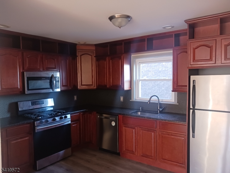 83 North Willow Street, Unit 1 Montclair, NJ 07042 - Photo 2 of 8 a kitchen with stainless steel appliances granite countertop a sink stove and refrigerator