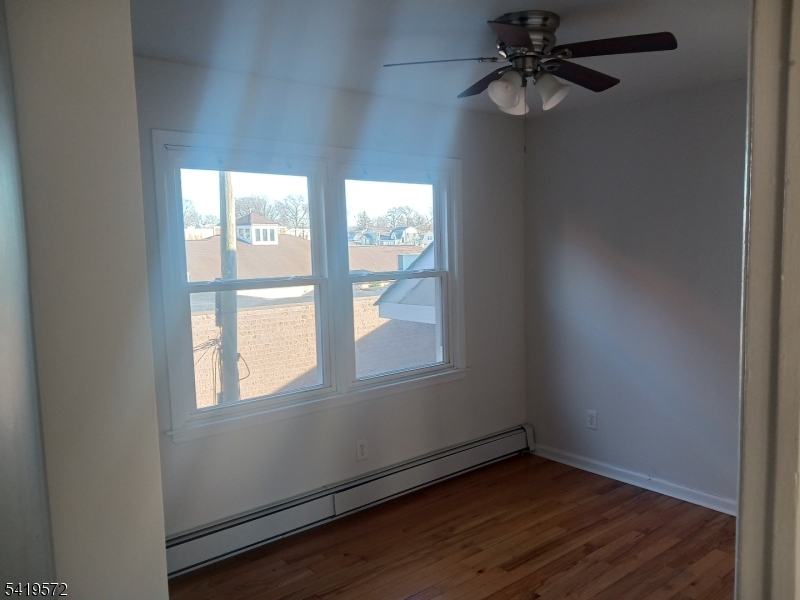 83 North Willow Street, Unit 1 Montclair, NJ 07042 - Photo 3 of 8 an empty room with wooden floor fan and windows