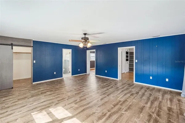 a view of a room with a chandelier fan and windows