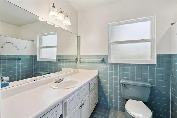 a bathroom with a sink a toilet and mirror