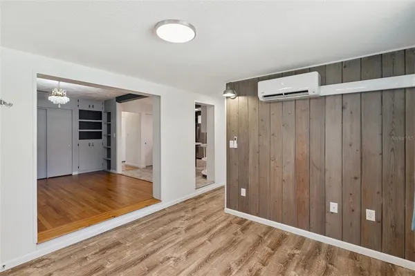a view of a livingroom with wooden floor and a bathroom