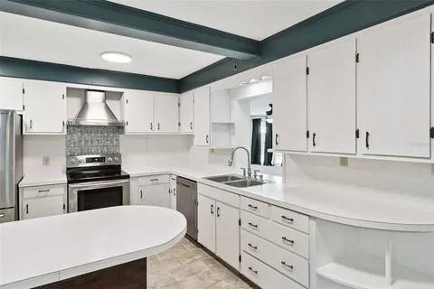 a kitchen with a stove and white cabinets