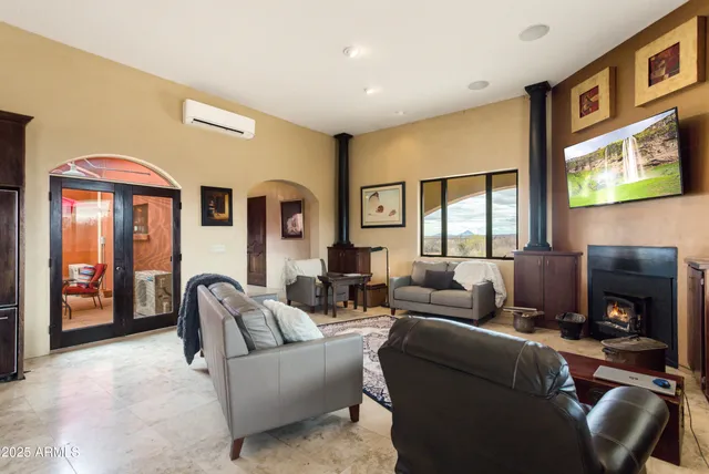 a view of a livingroom with furniture a flat screen tv and windows