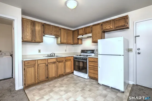 a kitchen with a stove a refrigerator and a sink