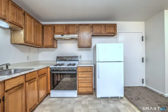 a kitchen with stainless steel appliances granite countertop a refrigerator stove and sink