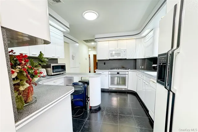 a kitchen with white cabinets and white appliances