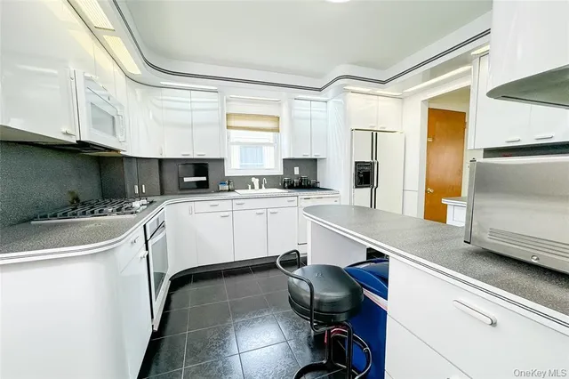 a kitchen with a sink a counter top space cabinets and appliances