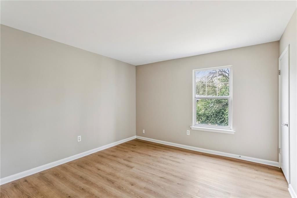 1150 Collier Road Northwest, Unit J11 Atlanta, GA 30318 - Photo 11 of 25 an empty room with wooden floor and windows