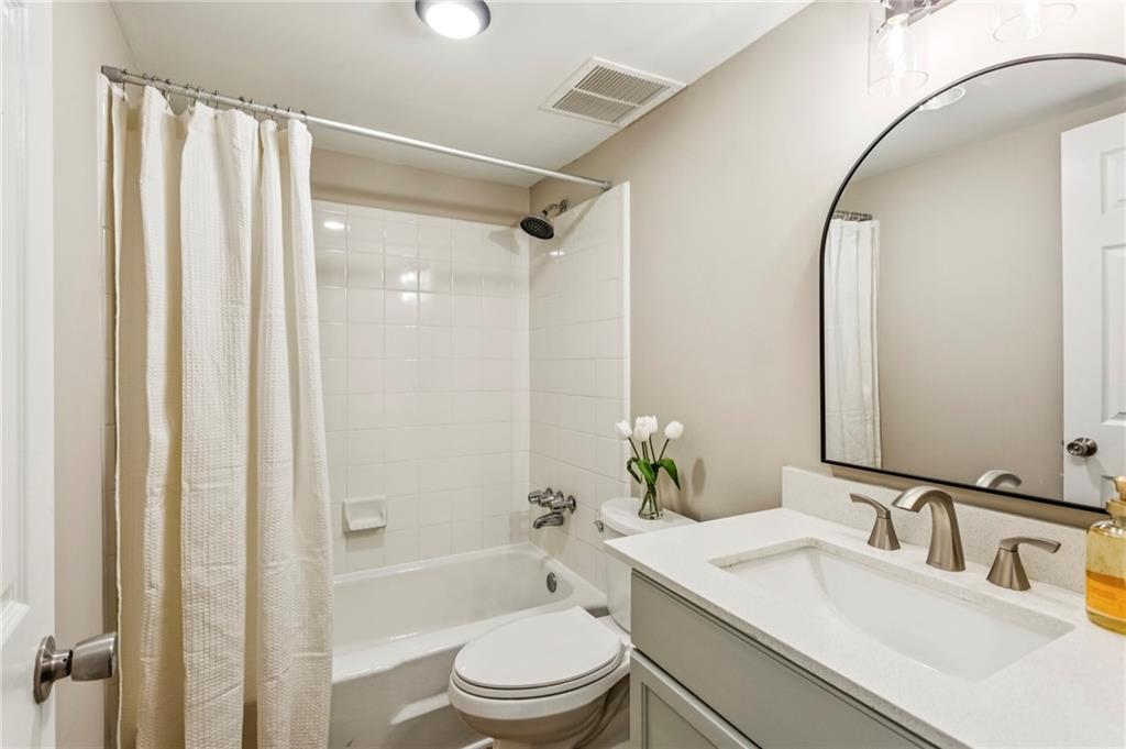 1150 Collier Road Northwest, Unit J11 Atlanta, GA 30318 - Photo 12 of 25 a bathroom with a granite countertop sink toilet and shower