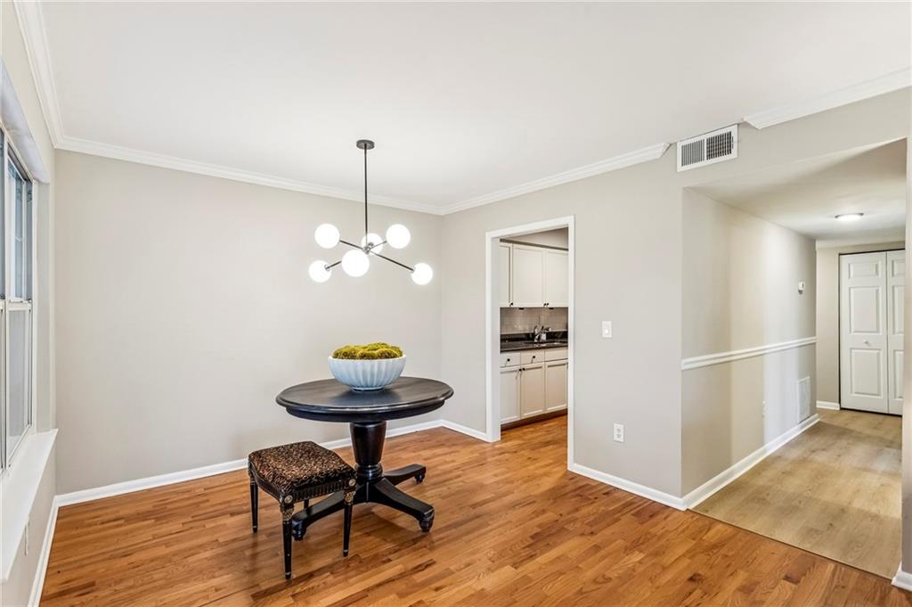 1150 Collier Road Northwest, Unit J11 Atlanta, GA 30318 - Photo 15 of 25 a view of a dining room with furniture and wooden floor